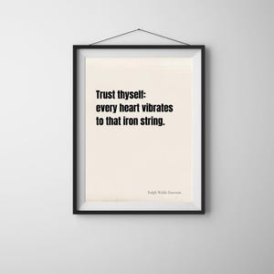 Puede incluir: Impresión enmarcada con la cita "Trust thyself: every heart vibrates to that iron string." en texto negro sobre un fondo crema. La impresión está en un marco negro y cuelga de una pared blanca.