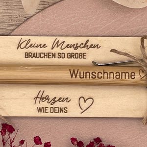 Detailaufnahme der Gravur auf der Holztafel und Kugelschreiber