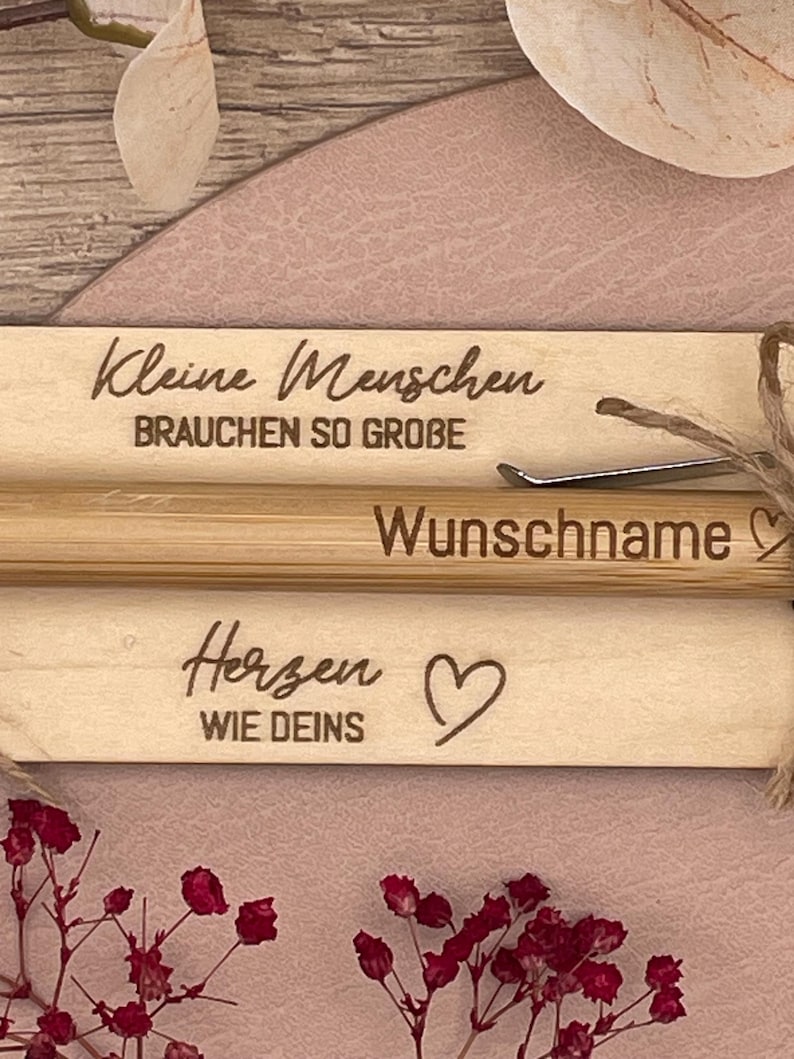 Detailaufnahme der Gravur auf der Holztafel und Kugelschreiber