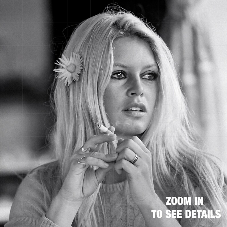 A black and white portrait of a woman with long blonde hair, holding a cigarette in her hand and looking off to the side.