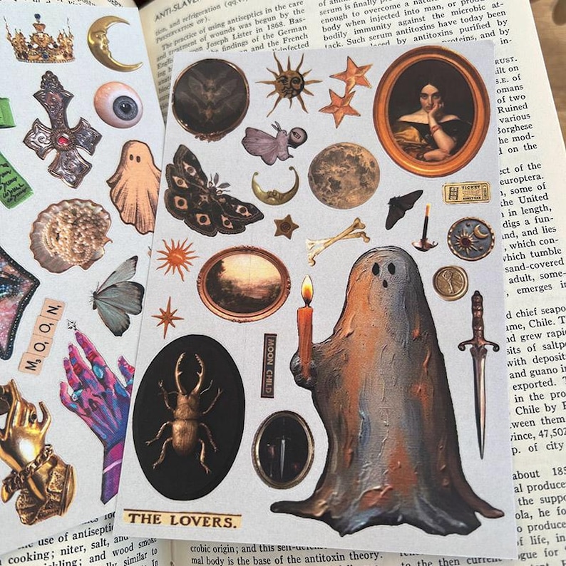 May include: A collection of vintage-style stickers featuring celestial and gothic imagery. Includes moons, stars, a ghost holding a candle, a portrait, insects, and the text "MOON" and "THE LOVERS."