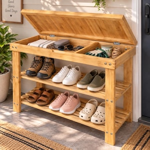 May include: A light brown bamboo shoe rack with a hinged storage lid. The unit features two slatted shelves holding various footwear, including boots, sneakers, sandals, and clogs. The open top compartment contains a folded cloth, sunglasses, and gloves.