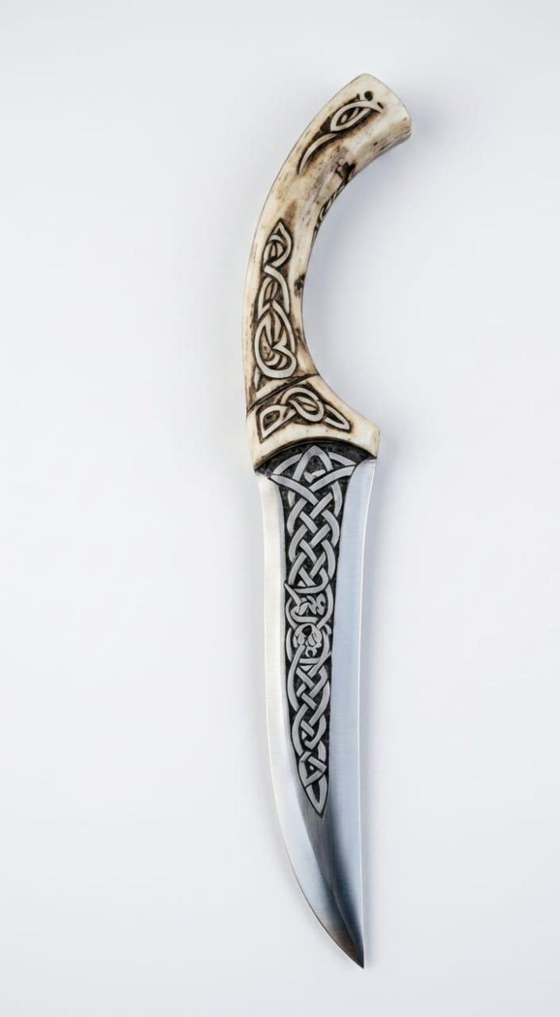 May include: A decorative knife with a curved handle and a silver blade. The handle is a light tan color with intricate Celtic knot designs carved into it. The blade also features Celtic knot patterns.