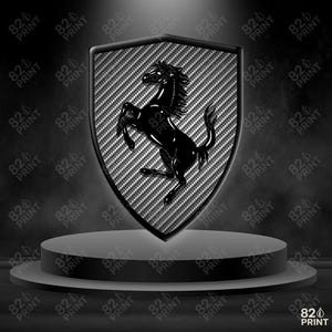 Może przedstawiać: Czarny i srebrny emblemat Ferrari z wierzgającym koniem na tle w kształcie tarczy. Emblemat ma fakturę z włókna węglowego i jest wyświetlany na szarej podstawie. Tekst "820 PRINT" powtarza się wokół obrazu.