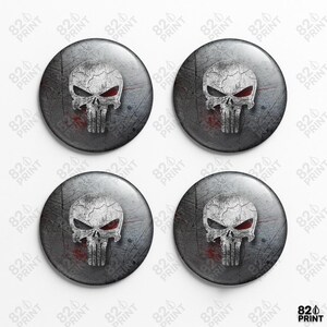 May include: Four circular, grey buttons displaying a white skull with red eyes and a distressed texture. The skull design is centred on a grey background with scratch marks. These buttons are a collectible item.