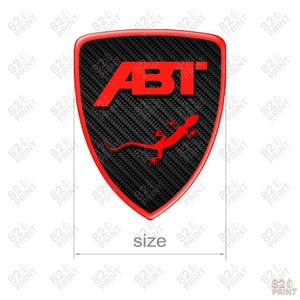 May include: A shield-shaped emblem with a red border and a carbon fiber texture. The emblem features the red text "ABT" and a red lizard graphic. The word "size" is written below the emblem.