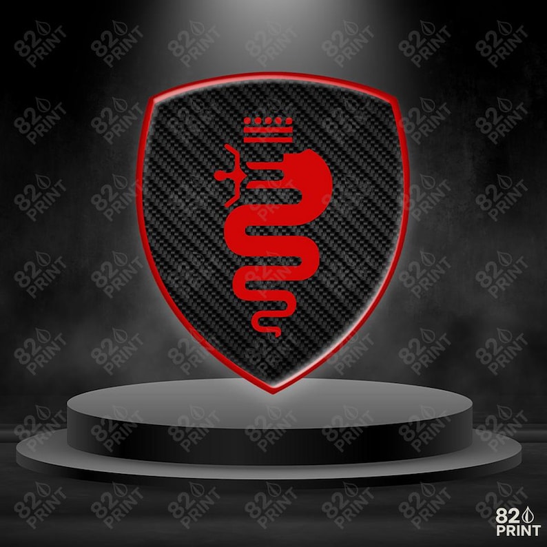 Pu&ograve; includere: Un emblema rosso e nero a forma di scudo con una trama in fibra di carbonio, con un design a serpente e corona rossi. L'emblema &egrave; esposto su un piedistallo grigio su sfondo scuro. Il testo "820 PRINT" &egrave; ripetuto.