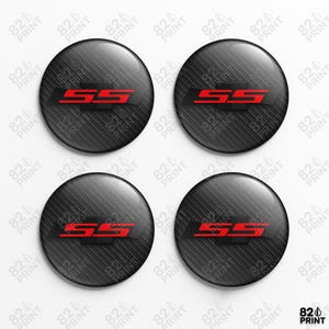 Peut inclure: Ensemble de quatre emblèmes ronds noirs avec une texture en fibre de carbone. Chaque emblème présente les lettres rouges "SS" sur un fond noir. Les emblèmes sont brillants et légèrement bombés.
