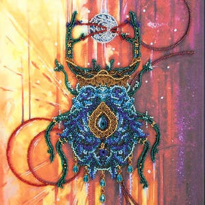 May include: A beaded artwork of a stylized beetle, featuring intricate details in shades of blue, green, and gold. The beetle is set against a vibrant background with a celestial motif, including a beaded moon and circular elements.
