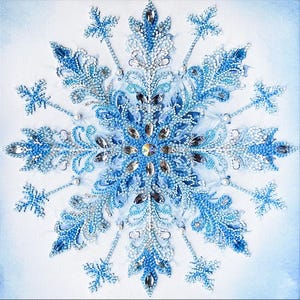 May include: A detailed, sparkling snowflake design in shades of blue and silver, embellished with rhinestones and beads. The artwork is centered on a white background, creating a wintery, festive theme. The snowflake's intricate details are highlighted with a variety of textures.