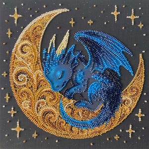 May include: A beaded artwork featuring a blue dragon curled up on a crescent moon. The moon is gold with intricate patterns, surrounded by gold stars on a dark background. The dragon's scales are a gradient of blue.