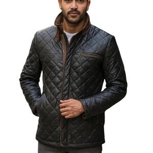 Könnte beinhalten: Schwarze, gesteppte Lederjacke mit braunem Kragen und Besatz. Die Jacke hat ein Rautenmuster und einen Reißverschluss. Der Markenname "JAB THREADS" ist in Weiß oben rechts aufgedruckt.