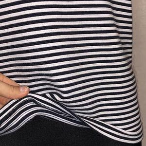 May include: A black and white striped top. The top features horizontal stripes in a classic nautical style. The fabric appears to be a soft knit material. The bottom portion of the image shows black leggings or pants.