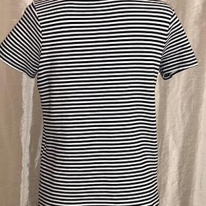 May include: A black and white striped t-shirt with short sleeves. The shirt is displayed on a mannequin. The stripes are horizontal and evenly spaced. The shirt is a classic nautical style.