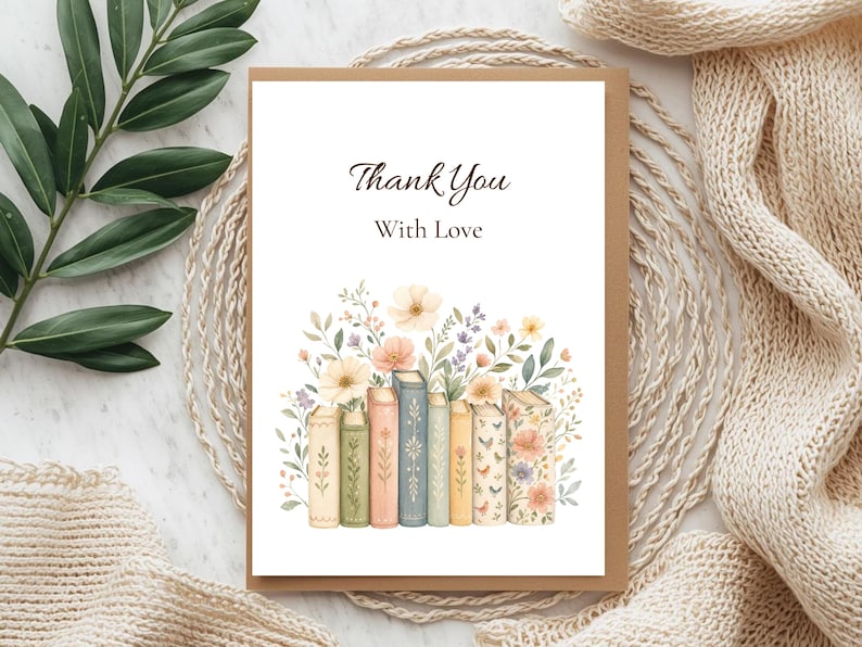 Puede incluir: Una tarjeta de felicitaci&oacute;n rectangular con fondo blanco que presenta el texto Thank You With Love en fuente negra cursiva y serif. Debajo del texto hay una ilustraci&oacute;n en acuarela de una fila de libros decorados con flores silvestres.