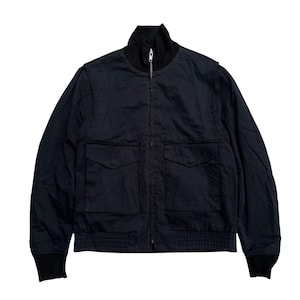 May include: A navy blue bomber jacket with a black ribbed collar, cuffs, and hem. The jacket features a zip-up front, two front pockets, and a relaxed fit. The jacket is made of a smooth, durable fabric.