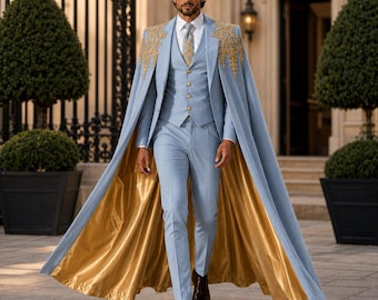 Puede incluir: Un traje de tres piezas azul claro que consta de chaleco, pantalón y una capa larga con bordados dorados en los hombros y forro dorado metálico. El conjunto incluye una camisa blanca, una corbata estampada y zapatos de vestir marrón oscuro.