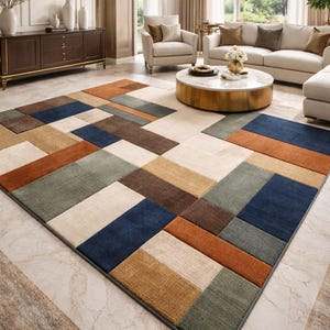 May include: A rectangular area rug with a geometric pattern in shades of blue, brown, beige, and green. The rug is placed on a marble floor in a living room setting. The rug's design features rectangular blocks.