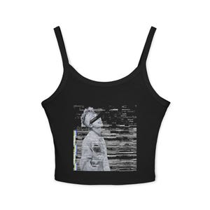 Op de afbeelding: Een zwarte mouwloze crop top met een centrale grafische print van een persoon in profiel met een zwarte balk over de ogen. De afbeelding heeft een digitaal glitch-effect met horizontale lijnen en een verticale strook kleur aan de linkerkant.