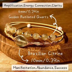 Könnte beinhalten: Zwei goldfarbene Armbänder mit Natursteinperlen. Eines hat goldene Rutilquarz-Perlen, 6 mm (0,6 cm). Das andere hat brasilianische Citrin-Perlen, 10 mm (1 cm). Das Bild enthält den Text: Verstärkung, Energieverbindung, Klarheit, Manifestation, Fülle, Erfolg.