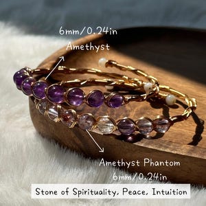 May include: Two amethyst and amethyst phantom bracelets. The bracelets are made with 6mm (0.24 in) beads and gold wire. The text on the image reads: Stone of Spirituality, Peace, Intuition.