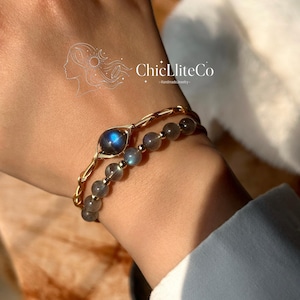 May include: A white ceramic mug with a black handle and the text "But First, Coffee" in a handwritten style. The mug is on a white surface. The mug is approximately 10 cm tall.