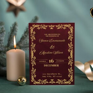 K&ouml;nnte beinhalten: Eine bordeauxfarbene Hochzeitseinladung mit goldenem floralem Rand und Text. Die Einladung enth&auml;lt die Namen Steven Emmanuele und Agustine Wilson, das Datum, die Uhrzeit und die Adresse. Eine brennende Kerze, eine kleine goldene Glocke und ein Tannenzweig im Hintergrund.