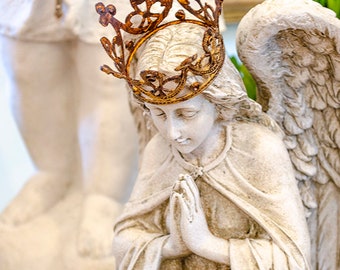 Estatua de ángel rezando arrodillado con corona