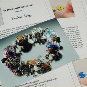 Può includere: Un primo piano di un braccialetto colorato realizzato con perline di argilla polimerica, perline di semi e argilla metallica argentata. Il braccialetto è intrecciato in un motivo a intreccio ad angolo retto e ha una chiusura a forma di fiore. "A Potpourri Bracelet" è scritto nella parte superiore dell'immagine.