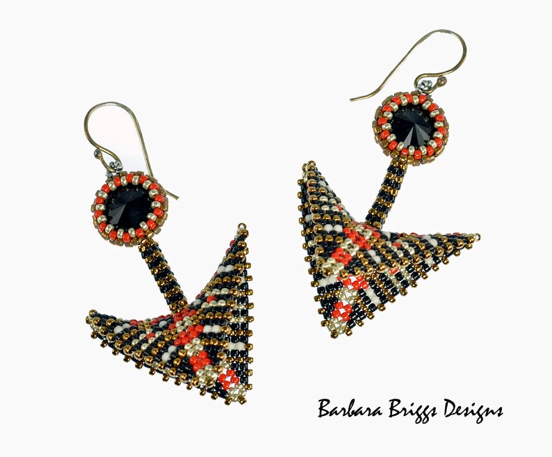 May include: A pair of black, white, and gold beaded earrings with red accents. The earrings are shaped like a pyramid with a black crystal at the top.