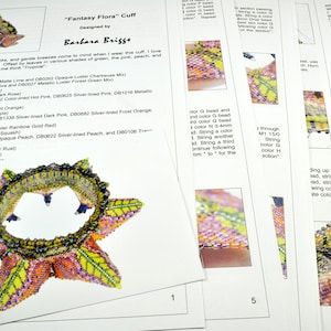 May include: A close-up of a beaded cuff bracelet with a starburst design. The cuff is made with a variety of colors, including green, pink, peach, and purple. The text "Fantasy Flora" Cuff Designed by Barbara Briggs" is printed on the page.