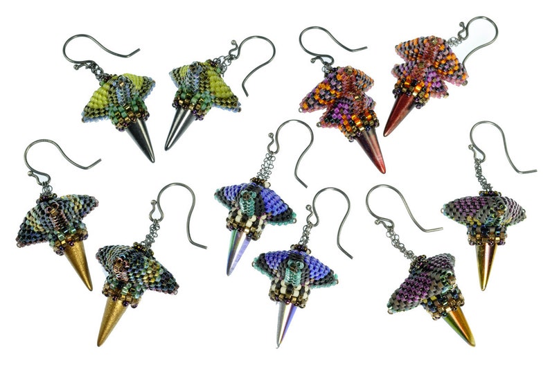 Puede incluir: Un conjunto de ocho pares de pendientes de cuentas. Cada par presenta una combinaci&oacute;n de colores &uacute;nica de cuentas iridiscentes, con un dise&ntilde;o puntiagudo en forma de cono. Los pendientes est&aacute;n hechos con ganchos de metal plateados.