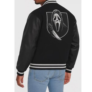 May include: Black varsity jacket with black leather sleeves and a white and gray striped collar and cuffs. The back features a white and gray graphic of a ghost face holding a knife.