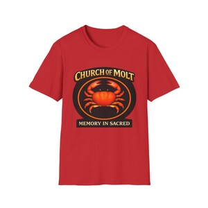 Puede incluir: Camiseta roja con un diseño de cangrejo dentro de un óvalo negro y naranja. El texto "CHURCH OF MOLT" está encima del cangrejo, y "MEMORY IN SACRED" debajo. La camiseta es de color rojo liso.