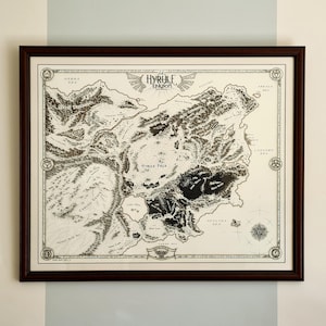 May include: A framed map of the Hyrule Kingdom, with detailed black and white illustrations of the land, seas, and geographical features. The map is in a dark brown wooden frame. The text "Hyrule Kingdom" is visible at the top of the map.