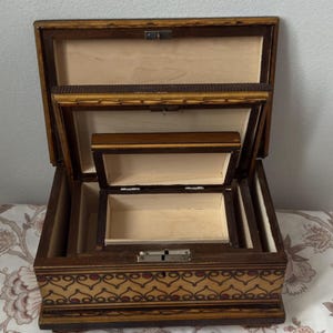 May include: A set of three ceramic mugs with a speckled, matte finish in cream, light grey, and dark grey. Each mug has a simple, minimalist design and a rounded handle.