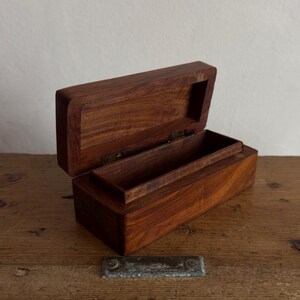 May include: A white ceramic mug with a black handle and the text "But First, Coffee" in a black, bold font. The mug is on a white surface. The mug is likely 11 ounces.