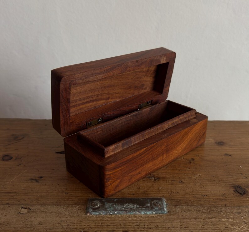 May include: A white ceramic mug with a black handle and the text "But First, Coffee" in a black, bold font. The mug is on a white surface. The mug is likely 11 ounces.