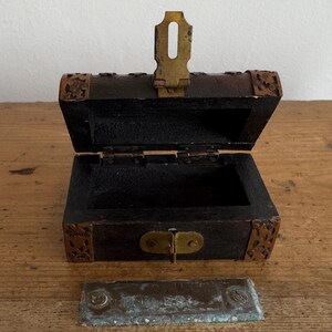 May include: A white ceramic mug with a black handle and the text "But First, Coffee" in a bold, black font. The mug is set against a neutral background, highlighting its simple design.