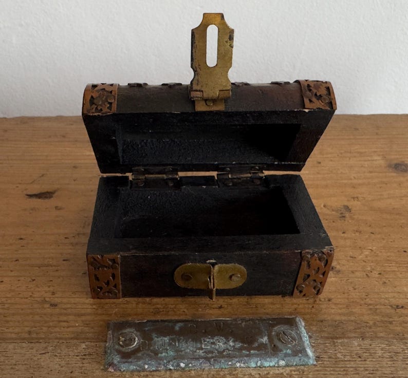 May include: A white ceramic mug with a black handle and the text "But First, Coffee" in a bold, black font. The mug is set against a neutral background, highlighting its simple design.