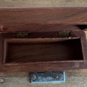 May include: A handmade, wooden serving tray with a natural finish. The tray features a rectangular shape with raised edges and integrated handles. The wood grain is visible, showcasing the tray's craftsmanship. Dimensions are approximately 18 inches long, 12 inches wide, and 2 inches high.