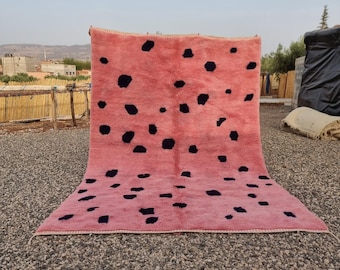 May include: A rectangular area rug featuring a vibrant pink base color with a scattered pattern of dark navy blue, irregular, organic-shaped spots distributed across the entire surface. The rug has a thick, textured pile and finished edges.