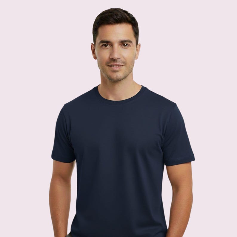 May include: A navy blue crew neck t-shirt. The short-sleeved shirt is made of a soft material. The person is wearing the shirt.