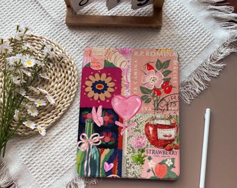 May include: A colorful tablet case with a collage design featuring flowers, a heart-shaped lollipop, and a jar of strawberry jam. The case has a pink and green color scheme and a white stylus is next to it.