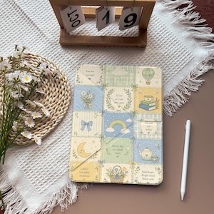 Könnte beinhalten: Eine rechteckige Tablethülle mit einem Raster aus pastellfarbenen Quadraten, die Illustrationen von einem Heißluftballon, Büchern, einem Regenbogen, einer Mondsichel, einer Teekanne und Blumen sowie Texten wie You are enough und Grow at your own pace zeigt.