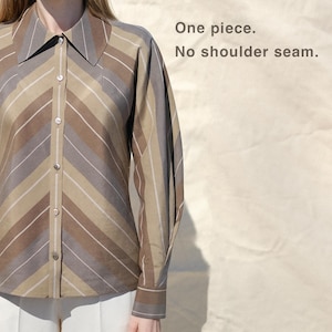 Peut inclure: Chemise à rayures marron, beige et grise, avec des manches longues et un col classique. Le texte "One piece. No shoulder seam." est affiché à droite. La chemise est boutonnée sur le devant.