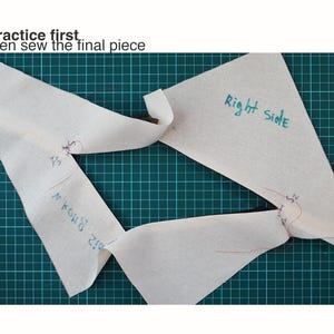 May include: Two off-white fabric pattern pieces with handwritten blue ink labels including "Right side" and "S1" and "S2" markings. The text "Practice first, then sew the final piece" is printed in black at the top of the image.