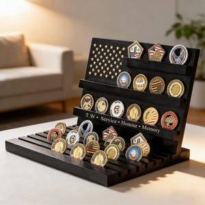 Puede incluir: Un expositor de monedas de madera negra con múltiples estantes, que contiene varias monedas de desafío militar. El expositor presenta un diseño de bandera estadounidense y la inscripción "T.W. Service • Honour • Memory". Las monedas son redondas y presentan diseños coloridos.