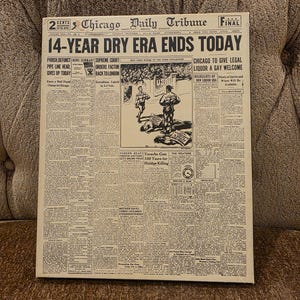 May include: A framed vintage newspaper front page from the Chicago Daily Tribune. The headline reads "14-YEAR DRY ERA ENDS TODAY." The newspaper is aged with visible text and illustrations, and the frame is a neutral color.