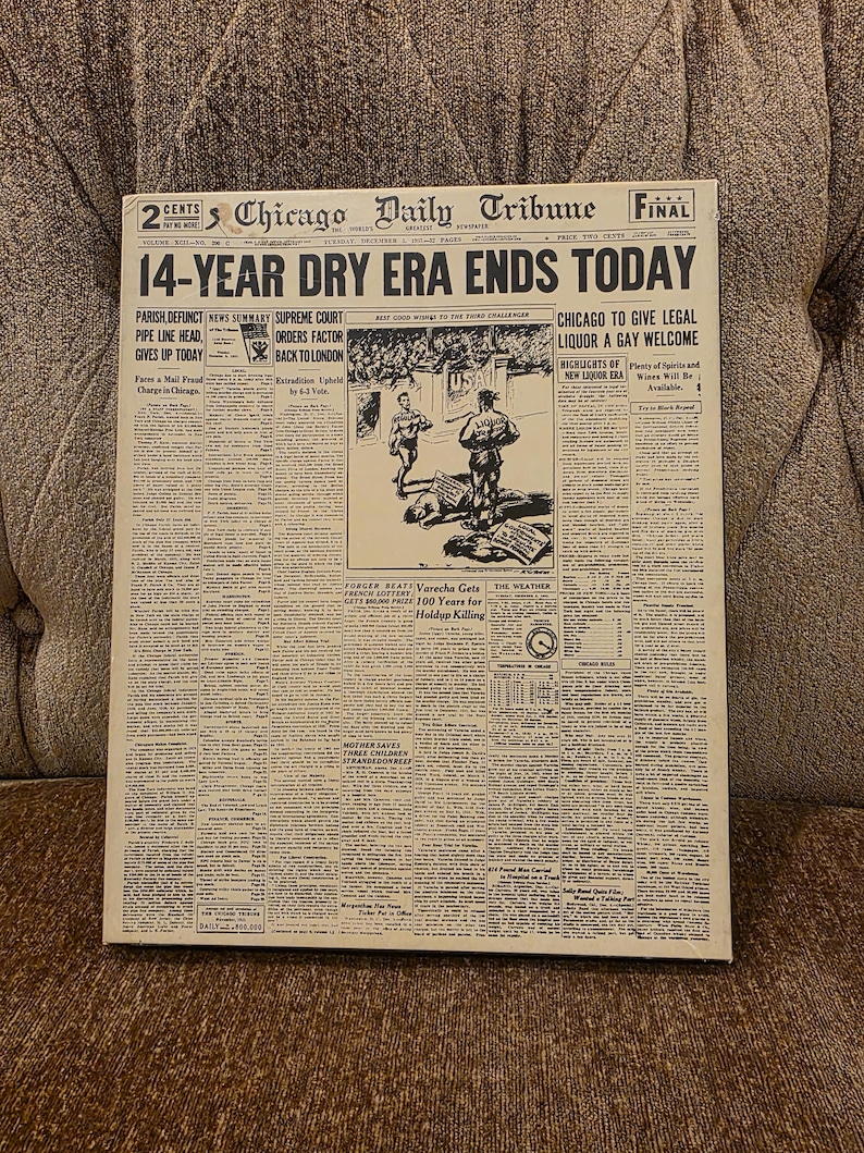 May include: A framed vintage newspaper front page from the Chicago Daily Tribune. The headline reads "14-YEAR DRY ERA ENDS TODAY." The newspaper is aged with visible text and illustrations, and the frame is a neutral color.